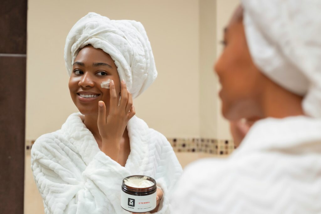 femme met de la crème de beauté
